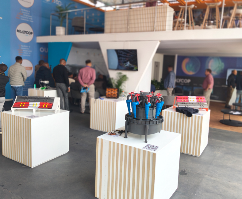 Industrial mining scale models on white display plinths at an exhibition